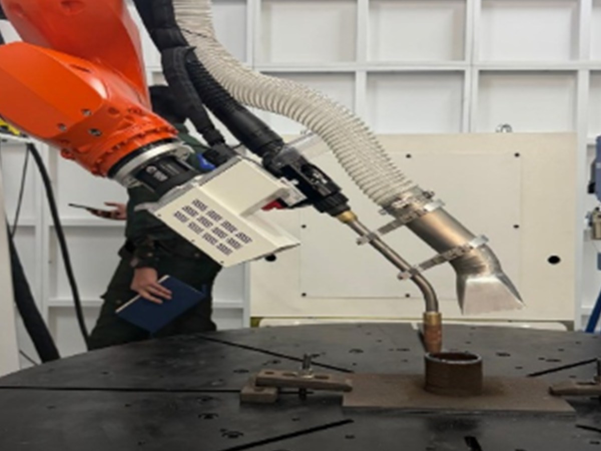 Robotic arm performing additive manufacturing