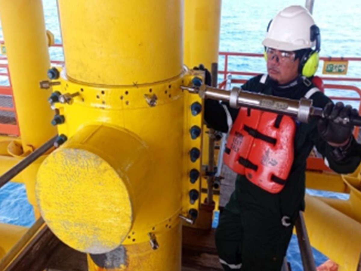 Technician performing controlled bolting offshore